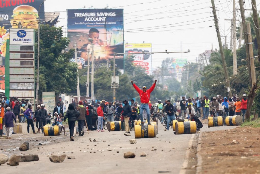 A demonstrator stands on a barricade cylinder during clashes with riot police in Nairobi on July 7, 2025. 